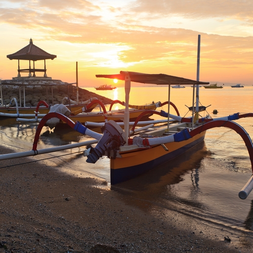Vissersboten op het strand van Sanur met Zonsondergang